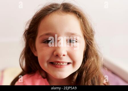 ritratto di ragazza che guarda la macchina fotografica nella sua camera da letto Foto Stock