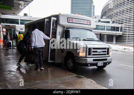 Mississauga, Canada. 22 Feb 2021. Il 22 febbraio 2021, i viaggiatori possono prendere un autobus navetta per gli hotel designati dal governo dell'aeroporto internazionale di Toronto a Mississauga, Ontario, Canada. A partire da Lunedi', i viaggiatori che arrivano in Canada in aereo sono tenuti a fare un test molecolare COVID-19 prima di uscire dall'aeroporto. Gli ospiti sono inoltre tenuti a mettere in quarantena per tre giorni in un hotel designato dal governo a proprie spese fino a quando non ottengono un risultato. Credit: Zou Zheng/Xinhua/Alamy Live News Foto Stock