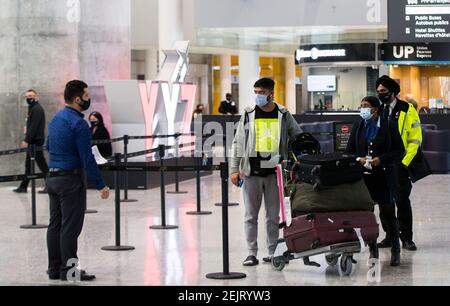 Mississauga, Canada. 22 Feb 2021. I viaggiatori aspettano un autobus navetta per un hotel designato dal governo presso l'aeroporto internazionale di Toronto a Mississauga, Ontario, Canada, il 22 febbraio 2021. A partire da Lunedi', i viaggiatori che arrivano in Canada in aereo sono tenuti a fare un test molecolare COVID-19 prima di uscire dall'aeroporto. Gli ospiti sono inoltre tenuti a mettere in quarantena per tre giorni in un hotel designato dal governo a proprie spese fino a quando non ottengono un risultato. Credit: Zou Zheng/Xinhua/Alamy Live News Foto Stock