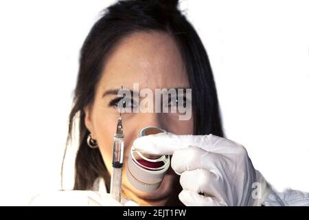 Medico femminile che prepara il vaccino contro la covid 19 usando siringa e. Flaconcino per la vaccinazione a Città del Messico Foto Stock