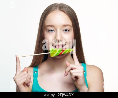 Ragazza adolescente che lecca il lollipop. Concetto di dente dolce. Foto Stock