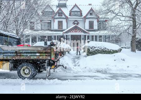 Milford, Stati Uniti. 22 Feb 2021. Un uomo libera una passerella innevata di fronte a una casa a Milford, Pennsylvania. Ancora un'altra tempesta si è abbattuta su un nordest stanco di neve, scendendo fino a sei pollici in alcune aree, compresa la Pennsylvania orientale. Credit: SOPA Images Limited/Alamy Live News Foto Stock