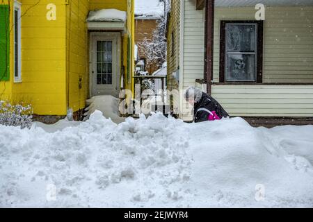 Port Jervis, Stati Uniti. 22 Feb 2021. Una donna a Port Jervis, New York tenta di liberare il marciapiede di fronte alla sua casa il lunedì pomeriggio. Un’altra tempesta si è abbattuta su un Nord-est innevato, scendendo fino a 10 cm in alcune aree, tra cui il sud dello stato di New York, il nord del New Jersey e la Pennsylvania orientale. Credit: SOPA Images Limited/Alamy Live News Foto Stock