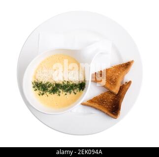 Zuppa di crema di formaggio con erbe aromatiche e toast tostati. Isolato su sfondo bianco. Foto Stock