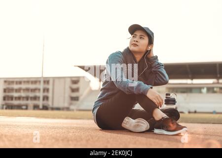 l'atleta sete fa una pausa, si siede sulla pista e la bottiglia d'acqua accanto a lei. Foto Stock