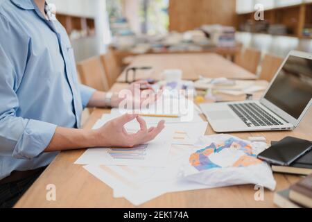 uomo d'affari meditando in ufficio facendo yoga in posa lotus. Foto Stock