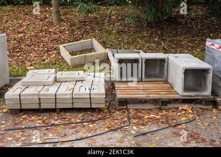 Un pallet di calcestruzzo armato scatolato e un pallet di coperchi di colino in un cantiere a nord italia orientale Foto Stock