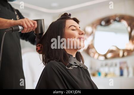 Cliente felice che ha i suoi capelli stylist da un professionista stylist Foto Stock