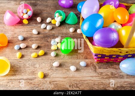 Vista ravvicinata dall'alto, immagine delle uova di pasqua in plastica riempite di cioccolatini prima della caccia all'uovo di pasqua. È un'attività divertente per i bambini che cercano Foto Stock