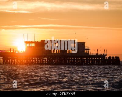 Worthing Beach, Worthing, Regno Unito. 23 Feb 2021. Il sole sorge su Worthing Pier. La mattina, dopo che è stata annunciata una tabella di marcia per la fine del blocco e le misure del covid-19, la costa meridionale è stata trattata a un'alba meravigliosa. Foto per credito: Julie Edwards/Alamy Live News Foto Stock