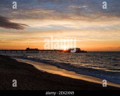 Worthing Beach, Worthing, Regno Unito. 23 Feb 2021. Il sole sorge su Worthing Pier. La mattina, dopo che è stata annunciata una tabella di marcia per la fine del blocco e le misure del covid-19, la costa meridionale è stata trattata a un'alba meravigliosa. Foto per credito: Julie Edwards/Alamy Live News Foto Stock