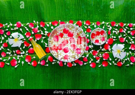 Songkran festival sfondo con fiori in acqua bocce e acqua profumata per la benedizione su sfondo umido foglia di banana. Foto Stock