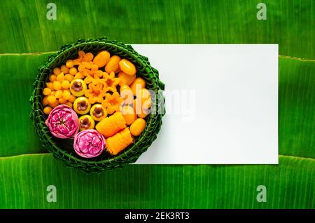 Dessert di nozze thailandesi su piatto di foglie di banana o krathong su carta bianca bianca e sfondo di foglia di banana. Foto Stock