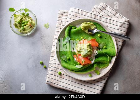 frittelle di spinaci verdi, crepes servito con salmone, avocado schiacciato Foto Stock