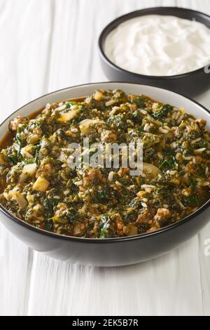 Il kiymaali turco Ispanak stufato Spinach con carne macinata, cipolle e riso in primo piano nella ciotola sul tavolo. Verticale Foto Stock