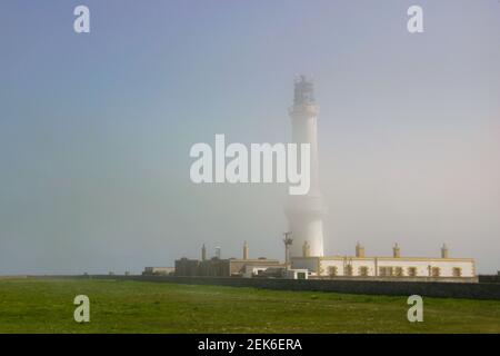 Faro di Girdleness che emerge attraverso la nebbia diradante in una primavera precoce mattina Foto Stock