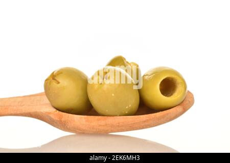 Diverse gustose e piccanti olive verdi salate in un cucchiaio di legno, primo piano, su sfondo bianco. Foto Stock