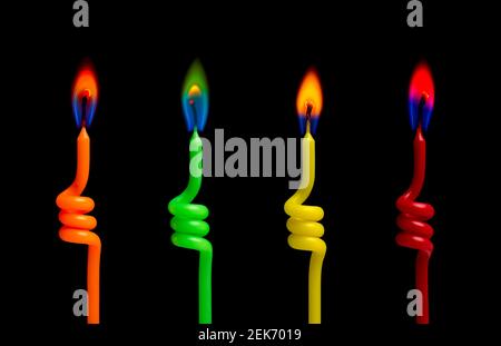 Quattro candele colorate si illuminano sullo sfondo nero Foto Stock