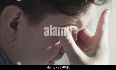 L'uomo stanco sfrega gli occhi. Primo piano. Foto Stock