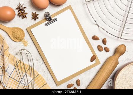 Ingredienti e utensili per torte da forno con foglio bianco per ricette, piatto. Concetto di cottura o cottura. Foto Stock