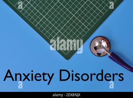 Layout dello stetoscopio e del pad grafico con L'ANSIA del testo DISTURBO su sfondo blu Foto Stock