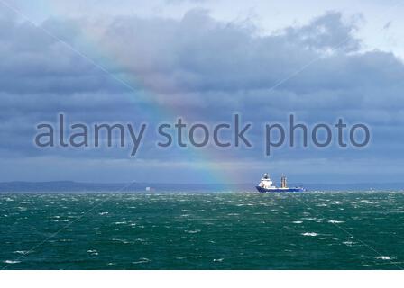 Edimburgo, Scozia, Regno Unito. 23 febbraio 2021. Kommandor Susan Offshore Tug/Supply Ship e arcobaleno nel Forth estuario visto dal porto di Granton breakwater in un pomeriggio arrugginito, soleggiato e piovoso. Credit: Craig Brown/Alamy Live News Foto Stock