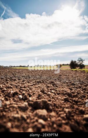 Campo agricolo appena arato contro il cielo Foto Stock