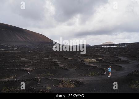 Donna turistica esplorando vigneto al Vulcano El Cuervo, Lanzarote, Spagna Foto Stock