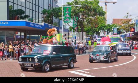 I minis guidano giù la strada con le decorazioni di Natale durante una parata di Natale a Tauranga, Nuova Zelanda Foto Stock