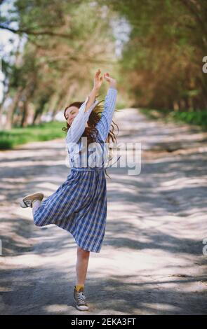 Donna allegra e matura che balla al parco durante la giornata di sole Foto Stock