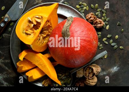 Noci, semi di zucca e squash di kuri rossi su una teglia rustica Foto Stock