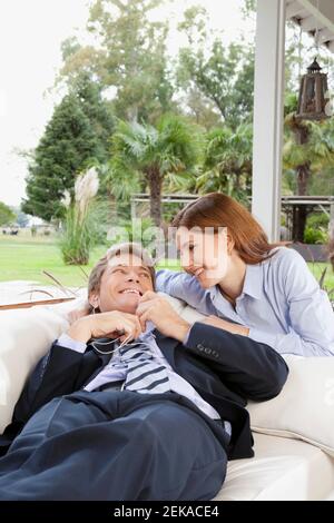 Uomo d'affari che ascolta la musica con una donna d'affari accanto a lui Foto Stock