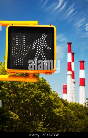 Segnale di crosswalk con pile di fumo sullo sfondo, New York City, New York state, USA Foto Stock