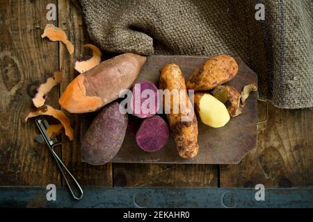 Diversi tipi di patate: Patate dolci, Annabelle, patate dolci viola su sfondo rustico Foto Stock