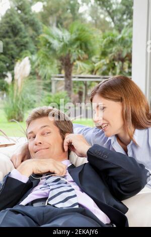 Uomo d'affari che ascolta la musica con una donna d'affari accanto a lui Foto Stock