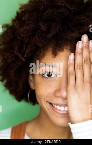 Donna felice coprendo metà faccia con mano in nuovo appartamento Foto Stock