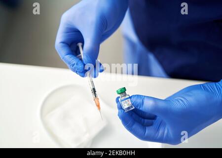 Mani che tengono il vaccino e la siringa di Coronavirus Foto Stock