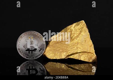 Investimento sui mercati azionari globali e concetto di criptovaluta: Una moneta argentata su molti pezzi d'oro su sfondo nero con spazio di copia Foto Stock