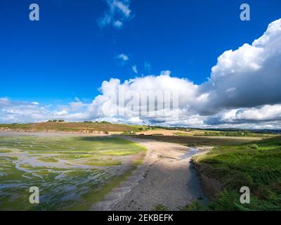 Vista panoramica della terra contro il cielo nuvoloso alla luce del sole Foto Stock