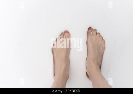 Donna a piedi nudi in piedi nella neve Foto Stock