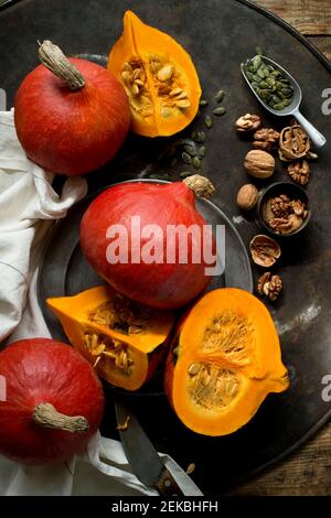 Noci, semi di zucca e squash di kuri rossi su una teglia rustica Foto Stock