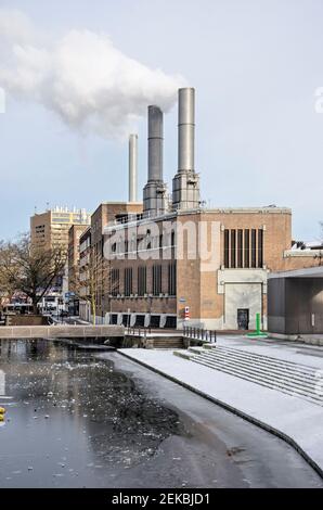 Rotterdam, Paesi Bassi, 14 febbraio 2021: La centrale elettrica del distretto di riscaldamento accanto al canale di Delftsevaart coperto di ghiaccio che mantiene la città calda Foto Stock