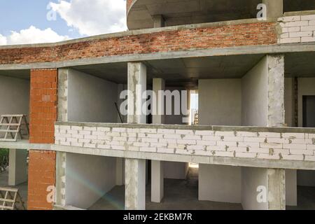 Nuova facciata dell'edificio degli appartamenti con molte finestre e camere in costruzione. Foto Stock