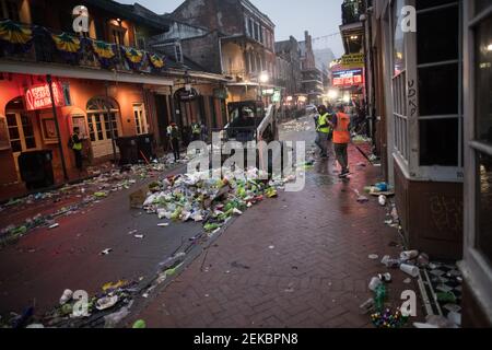 Bulldozer pulizia strade piene di rifiuti tarda notte mattina dopo Mardi Gras, New Orleans, Louisiana, Stati Uniti. Bourbon Street. Foto Stock