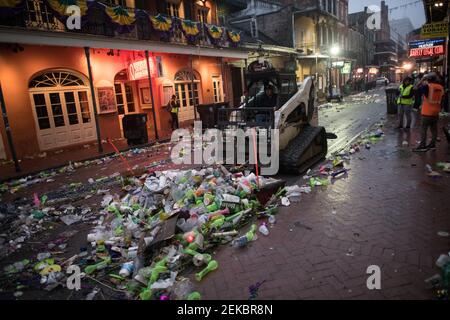 Bulldozer pulizia strade piene di rifiuti tarda notte mattina dopo Mardi Gras, New Orleans, Louisiana, Stati Uniti. Bourbon Street. Foto Stock