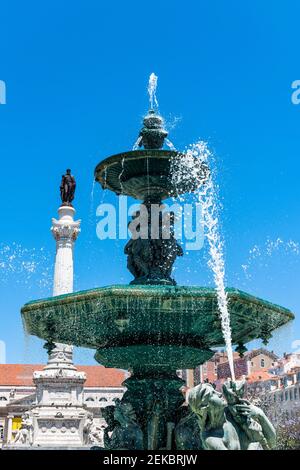 Portogallo, Lisbona, Rossio, Fontana su Praca Dom Pedro IV con colonna di Pedro IV sullo sfondo Foto Stock
