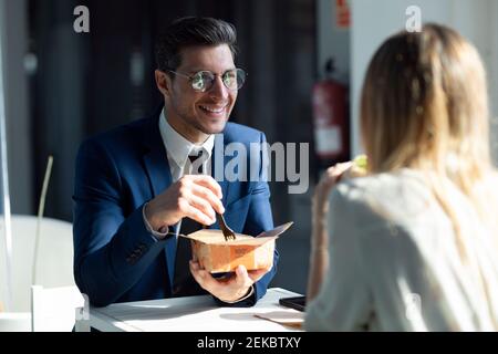 Gli uomini d'affari che pranzano mentre si siedono nella caffetteria dell'ufficio Foto Stock