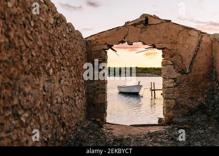 Battello ormeggiato sul molo nel lago durante il tramonto Foto Stock