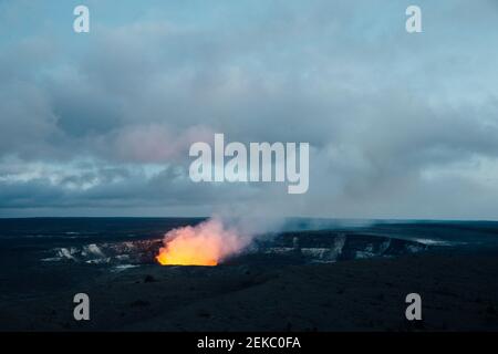 USA, Hawaii, HI, Glow dal lago di lava del cratere Halema'uma'u all'interno della caldera sommitale di Kilauea nel Parco Nazionale dei Vulcani delle Hawaii dopo il tramonto Foto Stock