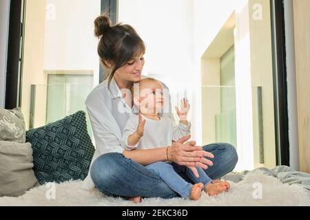 Madre seduta sul divano con la figlia del bambino Foto Stock